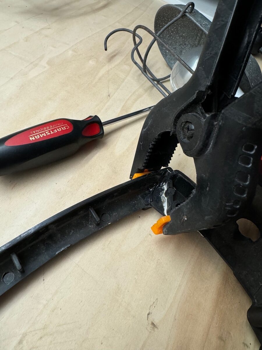 A clamp holding together a bakelite base as JB Weld cures. 